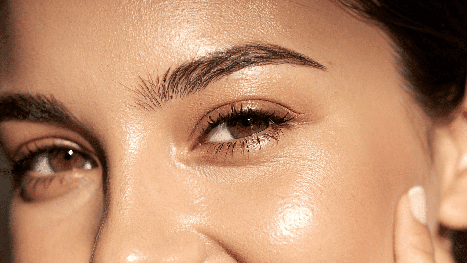 Close-up of a woman's face highlighting clear skin and groomed eyebrows.